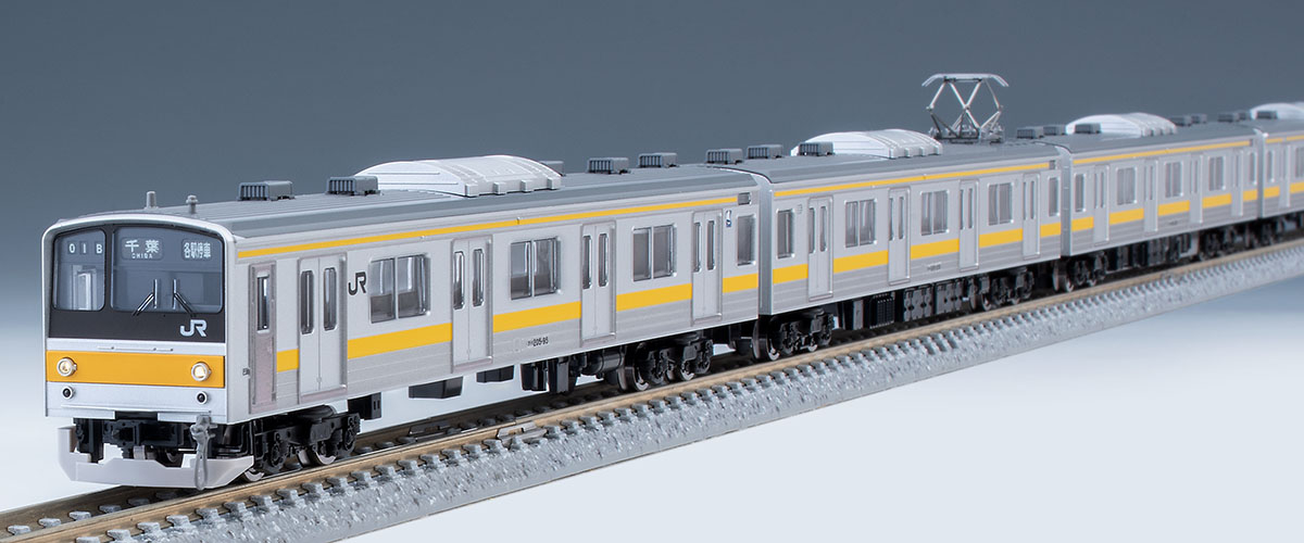 黄色帯と銀色の車体、スカート付き先頭部からの編成。模型写真：TOMIX公式商品資料。