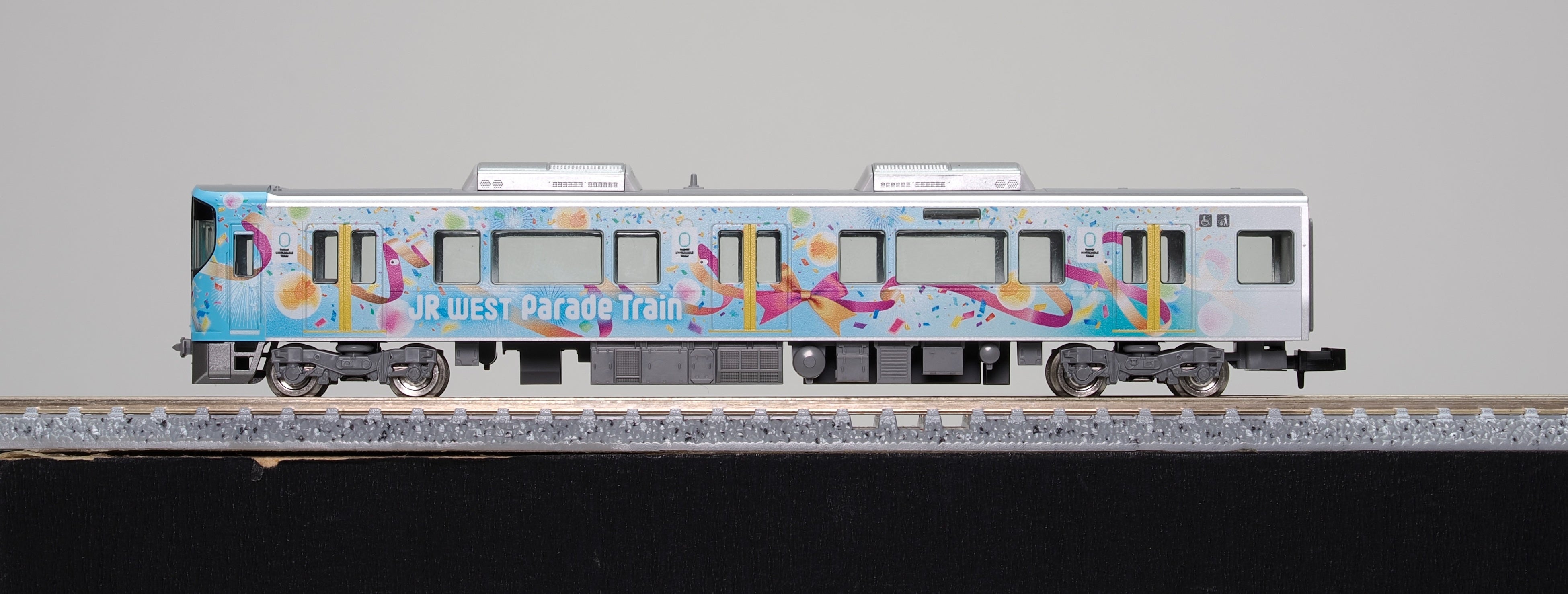 メーカー提供の側面カット。車体全体に施した花吹雪とJR WEST Parade Trainの表記を確認できる。